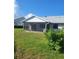 View of screened-in lanai with neutral decor overlooking green lawn and backyard at 482 Pendleton Pl, Venice, FL 34292
