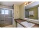 Bathroom showcasing a vanity, mirror, sink and shower with glass doors at 527 Walnut Cir, Venice, FL 34285