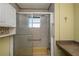 Bathroom featuring a shower with glass doors, window, and storage cabinet at 527 Walnut Cir, Venice, FL 34285