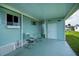 Relaxing covered patio featuring cool blue flooring, comfortable seating, and easy access to the outdoors at 527 Walnut Cir, Venice, FL 34285