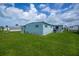 Exterior shot of mobile home featuring green lawn, blue sky, and blue siding at 527 Walnut Cir, Venice, FL 34285