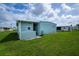 Exterior shot of mobile home with green lawn and blue sky in the background at 527 Walnut Cir, Venice, FL 34285