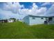 Exterior shot of mobile home featuring green lawn, blue sky, and blue siding at 527 Walnut Cir, Venice, FL 34285