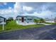 Inviting single-story home with a well-kept lawn, red front door, and convenient carport at 527 Walnut Cir, Venice, FL 34285
