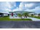 Charming single-story home with a well-maintained lawn, carport, and red front door at 527 Walnut Cir, Venice, FL 34285