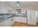 Efficient kitchen with white appliances, laminate flooring, and ample cabinet space for storage at 527 Walnut Cir, Venice, FL 34285