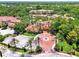 Aerial view of the community clubhouse, parking area, and lush landscaping with palm trees at 5459 Bentgrass Dr # 2-304, Sarasota, FL 34235