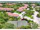 Aerial view of the community, tennis court, lush landscaping, buildings, and parking at 5459 Bentgrass Dr # 2-304, Sarasota, FL 34235