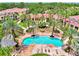 An aerial view of the community pool surrounded by palm trees and lush landscaping at 5459 Bentgrass Dr # 2-304, Sarasota, FL 34235