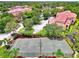 Aerial view of the community tennis court, parking lot, landscaping, and several buildings at 5459 Bentgrass Dr # 2-304, Sarasota, FL 34235