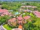 Aerial view of the community clubhouse, pool, spa, landscaping, and red tiled roofs at 5459 Bentgrass Dr # 2-304, Sarasota, FL 34235