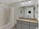 This bathroom offers a granite countertop, shower and tub and large mirror over the vanity at 5459 Bentgrass Dr # 2-304, Sarasota, FL 34235