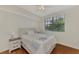 A comfortable bedroom with wood floors and a window that provides natural light and serene views at 5459 Bentgrass Dr # 2-304, Sarasota, FL 34235