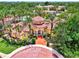 An inviting yellow clubhouse entrance with a circular brick driveway and lush landscaping at 5459 Bentgrass Dr # 2-304, Sarasota, FL 34235