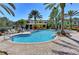 This resort-style pool features sun loungers, palm trees, beautiful pavers, and tropical plants at 5459 Bentgrass Dr # 2-304, Sarasota, FL 34235