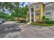 Attractive yellow condominium building with well-maintained landscaping and ample parking at 5459 Bentgrass Dr # 2-304, Sarasota, FL 34235