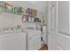 Clean laundry area with washer, dryer, shelving, and water heater at 5459 Bentgrass Dr # 2-304, Sarasota, FL 34235