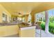 Open outdoor kitchen with granite counters, stainless steel sink, bar seating and ceiling fans at 5459 Bentgrass Dr # 2-304, Sarasota, FL 34235