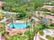 Aerial view of a kidney-shaped pool with brick surround, pergola and tropical landscaping at 5459 Bentgrass Dr # 2-304, Sarasota, FL 34235