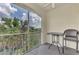 Relax on the screened balcony with a table and chair overlooking the landscape at 5459 Bentgrass Dr # 2-304, Sarasota, FL 34235