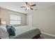Bedroom showcasing a queen size bed, ceiling fan, and natural light from a window at 5828 Lincoln Rd, Venice, FL 34293