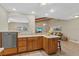 Cozy kitchen featuring wood cabinets, tile flooring, and a view into the living area at 5828 Lincoln Rd, Venice, FL 34293