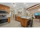 Open kitchen design with wood cabinets, island seating, and stainless steel appliances at 5828 Lincoln Rd, Venice, FL 34293