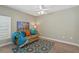 Cozy room featuring a comfortable couch, colorful rug, and a ceiling fan for added comfort at 5828 Lincoln Rd, Venice, FL 34293