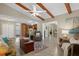 Inviting living room with wood-beamed ceiling, tile floors, and open layout to kitchen at 5828 Lincoln Rd, Venice, FL 34293