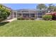 Lush backyard with a screened-in pool area and a well-maintained lawn at 609 Madrid Ave, Venice, FL 34285