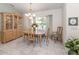 Inviting dining room boasting a classic chandelier, wooden furniture, and a sunlit window with sheer curtains at 609 Madrid Ave, Venice, FL 34285