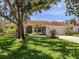 Charming single-story home boasting a well-kept lawn, mature trees, and a cozy entrance with a verdant front yard at 609 Madrid Ave, Venice, FL 34285