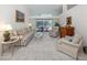 Bright living room with neutral tones, tile flooring, and sliding glass doors leading to the pool area at 609 Madrid Ave, Venice, FL 34285