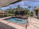 Landscaped screened-in pool with a waterfall feature and lots of privacy at 609 Madrid Ave, Venice, FL 34285
