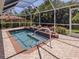 Serene screened-in pool with brick pavers, a waterfall feature, and lush landscaping at 609 Madrid Ave, Venice, FL 34285