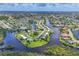 Community aerial showcasing waterfront homes, lush greenery, and a serene lakeside setting in a coveted neighborhood at 6821 Marius Rd, North Port, FL 34287