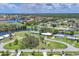 Sprawling community aerial featuring lush greenery, serene ponds, and charming homes in a tranquil lakeside setting at 6821 Marius Rd, North Port, FL 34287