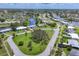 An aerial view showcasing a community nestled along waterfront canals, complemented by lush greenery and a central park at 6821 Marius Rd, North Port, FL 34287