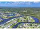 Aerial view of a waterfront community with a mix of homes, canals, and lush greenery at 6821 Marius Rd, North Port, FL 34287