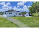 Home exterior with a well-maintained backyard, privacy fence, and patio, perfect for outdoor enjoyment at 6821 Marius Rd, North Port, FL 34287