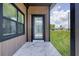 Stylish front door with decorative glass, set against a modern wood-accented porch with marble tile at 6821 Marius Rd, North Port, FL 34287