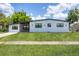 Charming single-story home featuring a well-manicured lawn, modern windows, and a freshly painted exterior at 6821 Marius Rd, North Port, FL 34287