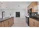 Modern kitchen features wood cabinets, black countertops, and stainless steel appliances at 6821 Marius Rd, North Port, FL 34287