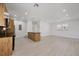 Open-concept living room with a modern kitchen featuring wood-look cabinets and stainless steel appliances at 6821 Marius Rd, North Port, FL 34287