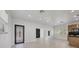 Bright and open-concept living room showcasing wood-look floors, modern lighting, and a view into the kitchen at 6821 Marius Rd, North Port, FL 34287