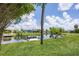Backyard with views of the canal with a wooden dock. The grassy lawn leads to the waterfront at 6821 Marius Rd, North Port, FL 34287