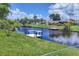 Canal view with lush green grass and private docks for boating and relaxation on a sunny, cloud filled day at 6821 Marius Rd, North Port, FL 34287