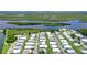 High aerial view of a large mobile home community adjacent to a lake and wetland area, offering picturesque scenery at 738 Riverview Cir, North Port, FL 34287