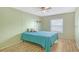 Cozy bedroom with natural light, a ceiling fan, and light wood flooring at 738 Riverview Cir, North Port, FL 34287