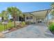 Inviting single-story home featuring a carport, screened-in porch, and well-maintained landscaping with palm tree and address at 738 Riverview Cir, North Port, FL 34287